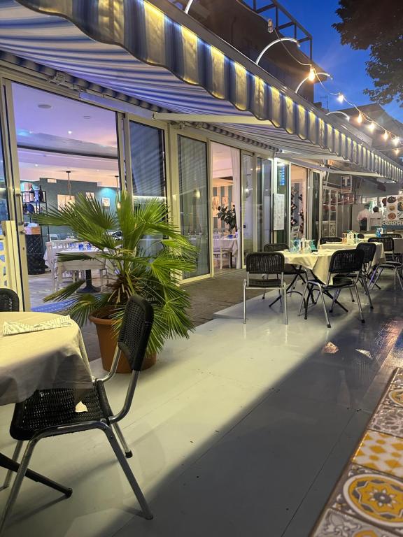 un patio avec des tables et des chaises sur un bâtiment dans l'établissement Hotel Blue Moon B&B, à Rimini