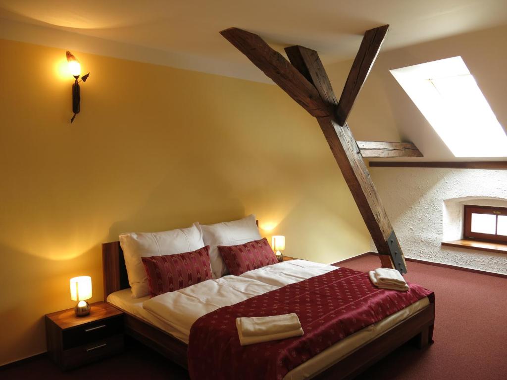 a bedroom with a bed in a room with a skylight at Penzion Elzet in Třeboň