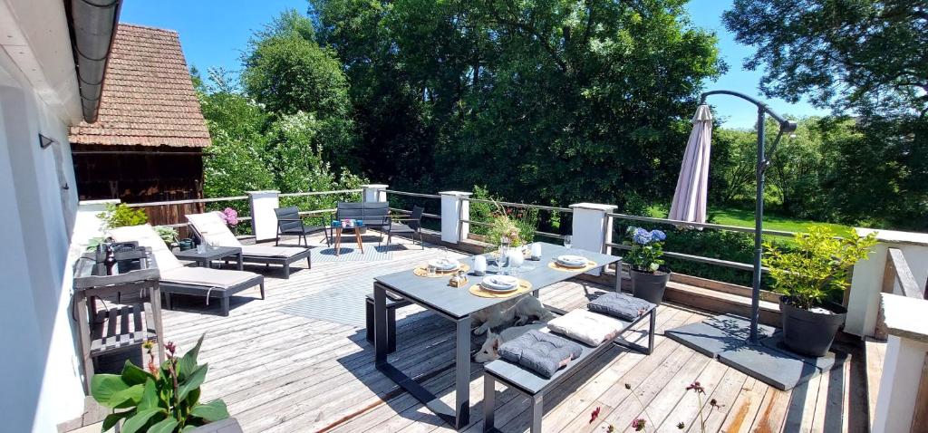 un patio con tavolo e sedie su un ponte di Ferienwohnungen Marienweiher a Marktleugast