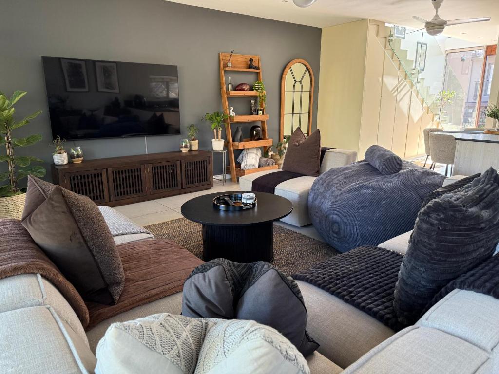 a living room with two couches and a tv at Stylish Ballito Home - Zimbali Wedge in Ballito