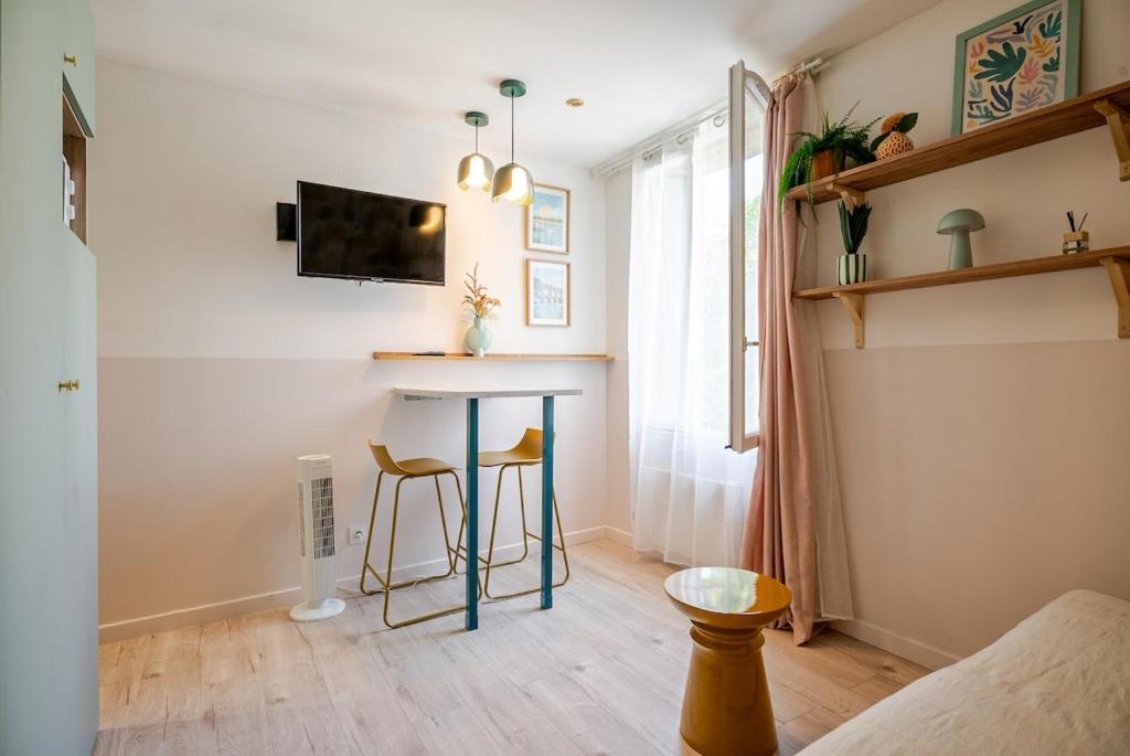 ein Wohnzimmer mit einem Tisch und 2 Stühlen in der Unterkunft Studio centre 10 min gare comedie in Montpellier