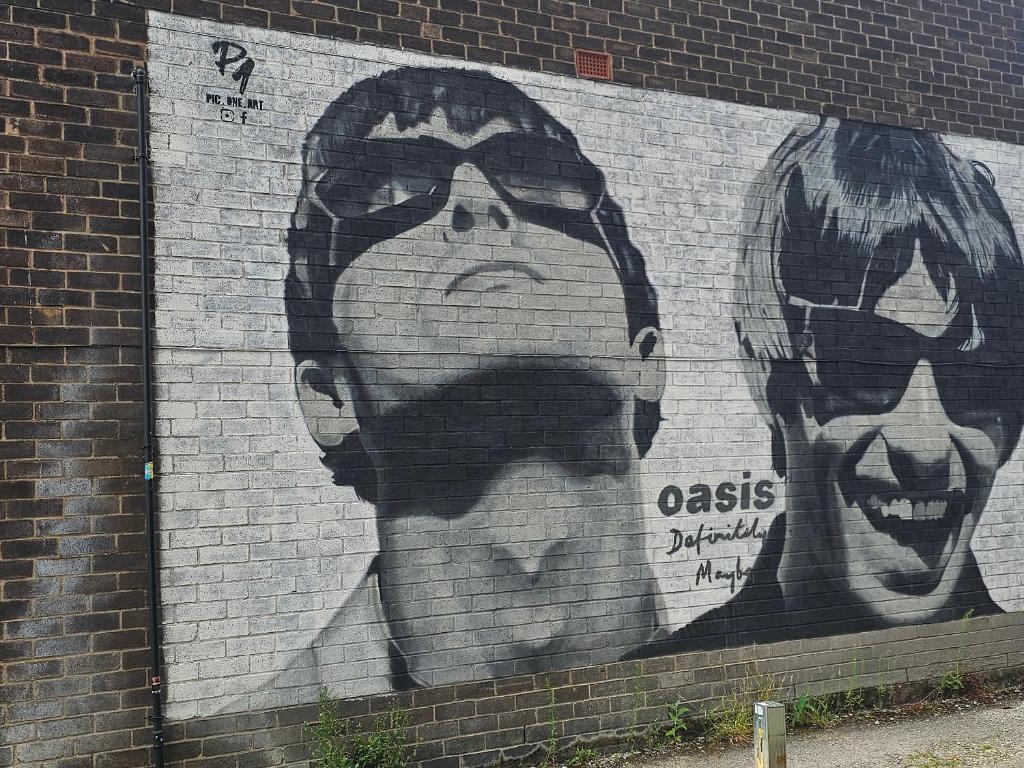 a mural of a man and two faces on a brick wall at Forest View- Oasis Mural -Didsbury Zen Sleeps 10 in Manchester