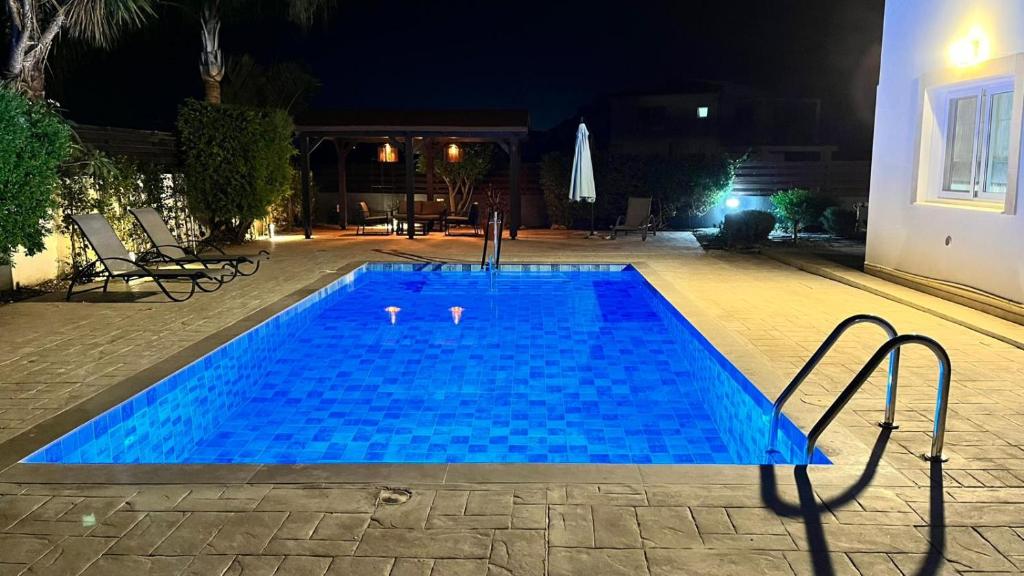 a large blue swimming pool at night at Villa Porta Aurea in Ayia Napa