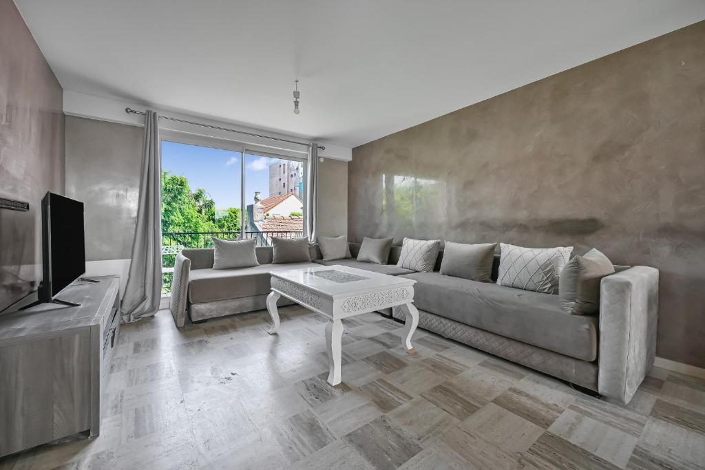 un salon avec un canapé et une télévision dans l'établissement Le City Mood - 2 pers - Wifi - Stade de France, à Aubervilliers