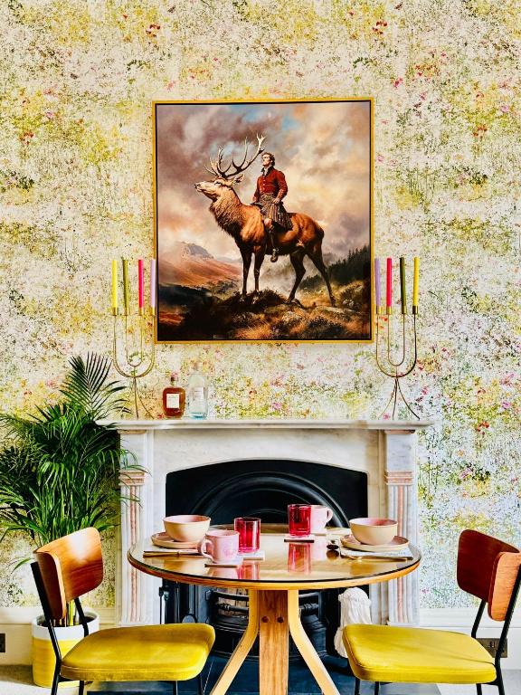 a room with a table with a painting of a man riding a deer at Scot Townhouse in Edinburgh