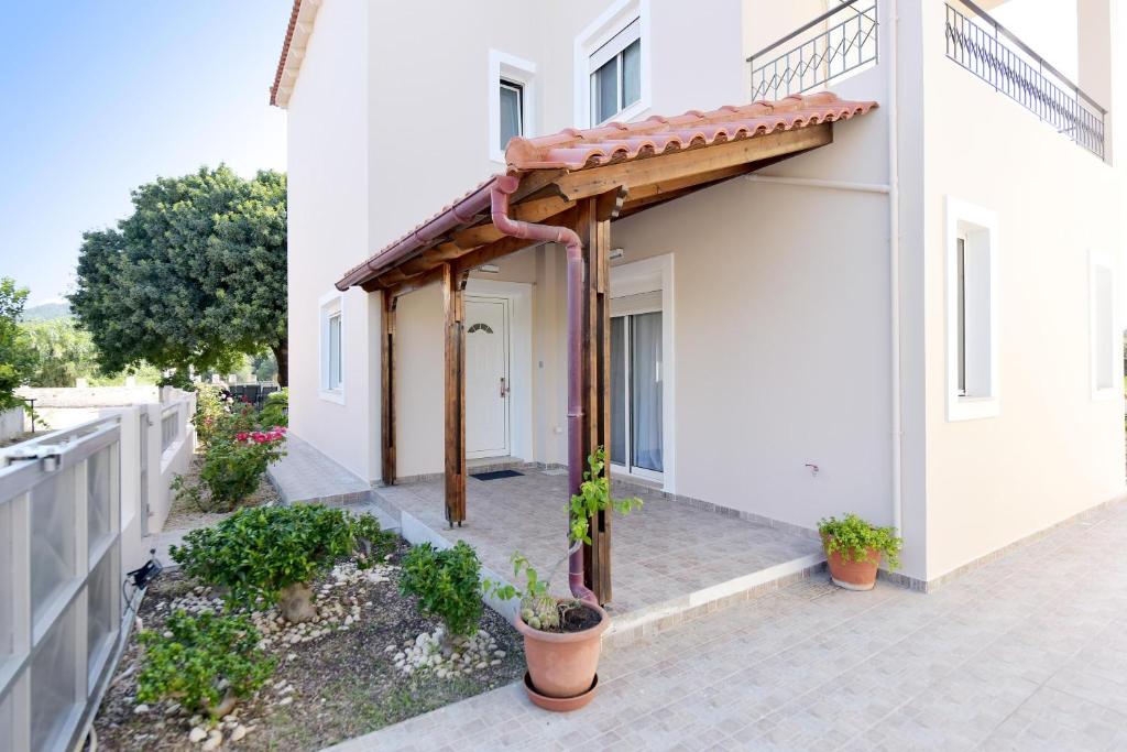 a pergola on the side of a white house at Seraina House in Pastida
