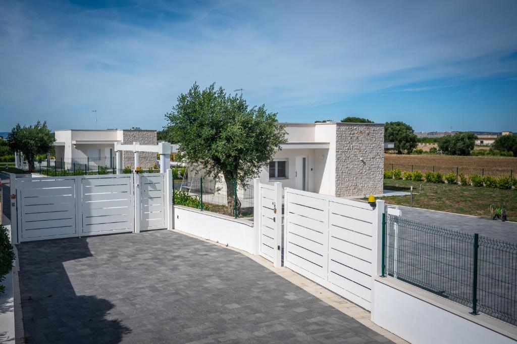 une clôture blanche avec un portail devant une maison dans l'établissement LikeHome Taranto - 2 ville indipendenti, à Tarente
