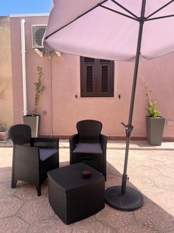 アルゲーロにあるRita's House Algheroのパティオ(椅子、パラソル、テーブル付)