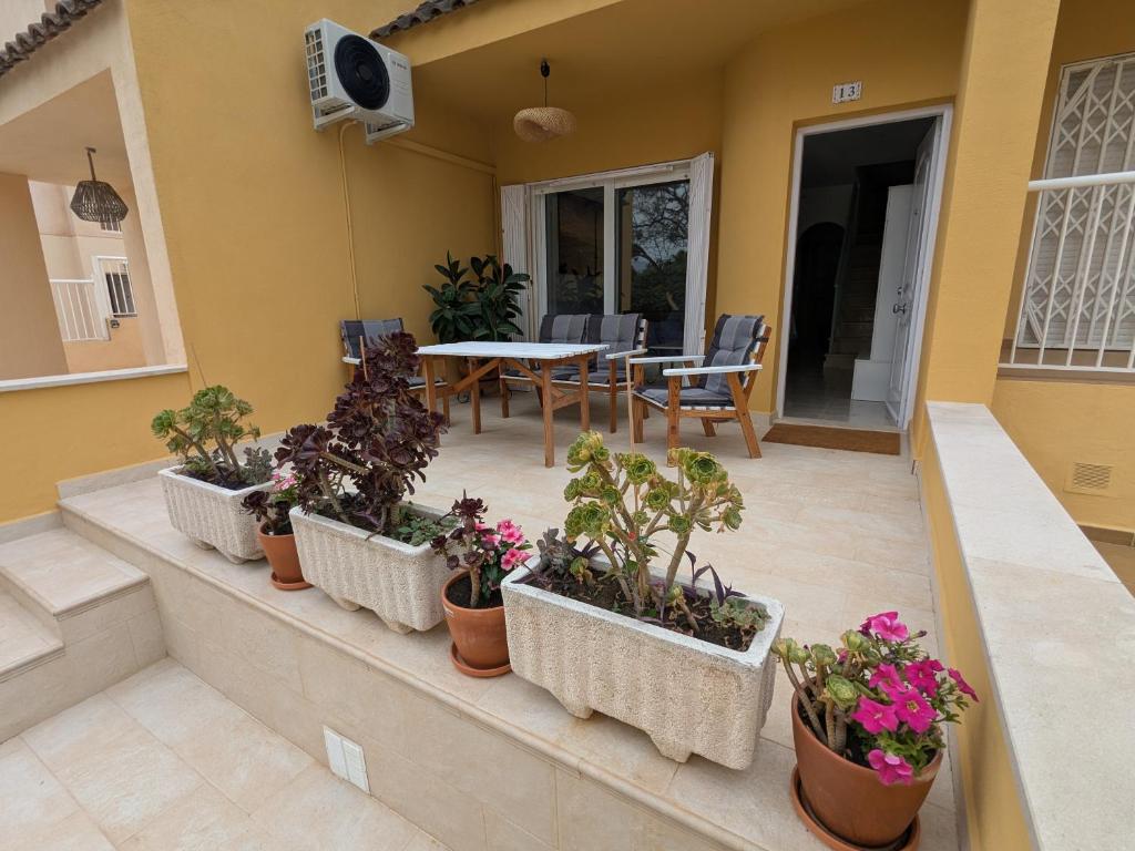 a patio with a table and potted plants on it at Tu lugar feliz al lado del mar in Mazarrón