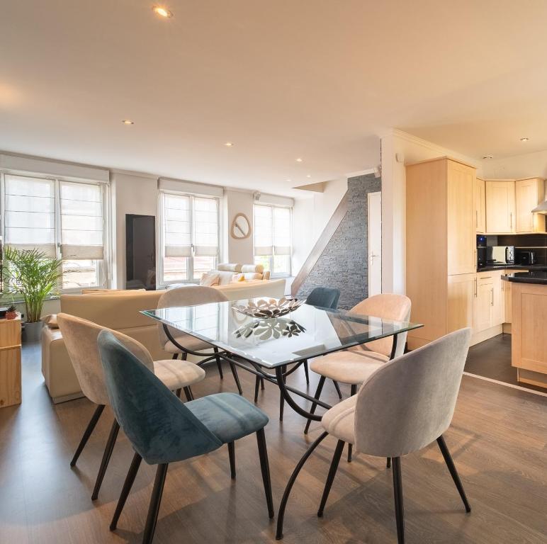 une cuisine et une salle à manger avec une table et des chaises en verre dans l'établissement Duplex avec parking La Parenthèse Pétillante, à Épernay