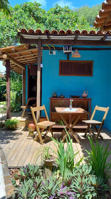 アライアル・ダジュダにあるCasa Paiol loft no centro do Arraialの青い壁のパティオ(テーブル、椅子付)