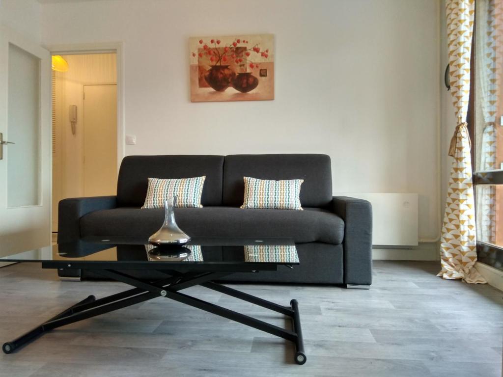 a living room with a couch and a glass coffee table at Budget apart with balcony in Saint-Denis