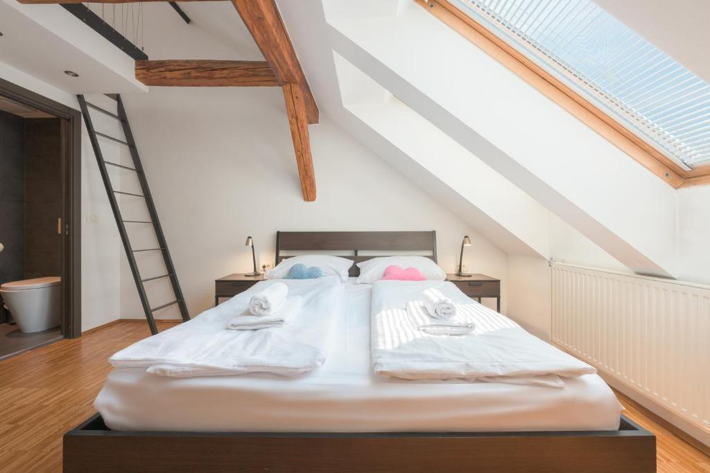 a bedroom with a large white bed in a attic at ATIK ROOMS in Ljubljana