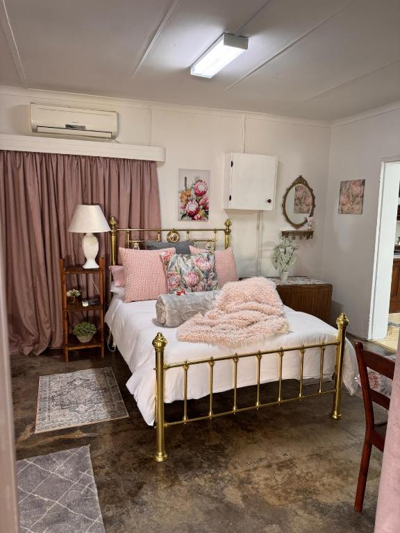 Un dormitorio con una cama con marco dorado. en Gentle Snooze Inn, en Britstown