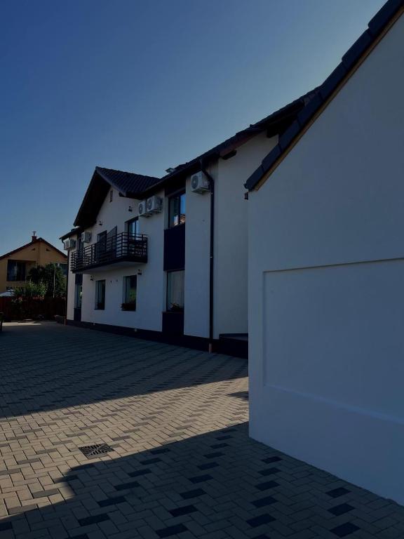 ein weißes Gebäude mit einer Tür auf einem Parkplatz in der Unterkunft Casa Lucia in Sibiu