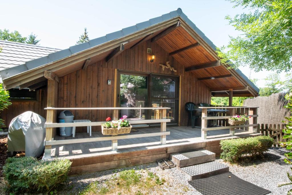una cabaña de madera con un gran porche delantero en Chalet Four Seasons, en Durbuy