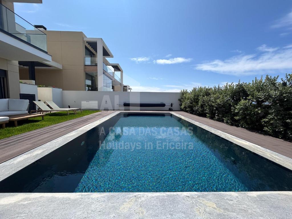 een zwembad in een villa met een huis bij Casa Mango by ACasaDasCasas in Ericeira