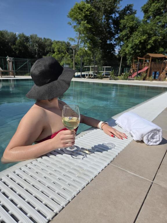 mężczyzna siedzący na ławce z kieliszkiem wina w obiekcie Hotel Csillag Tokaj w Tokaju