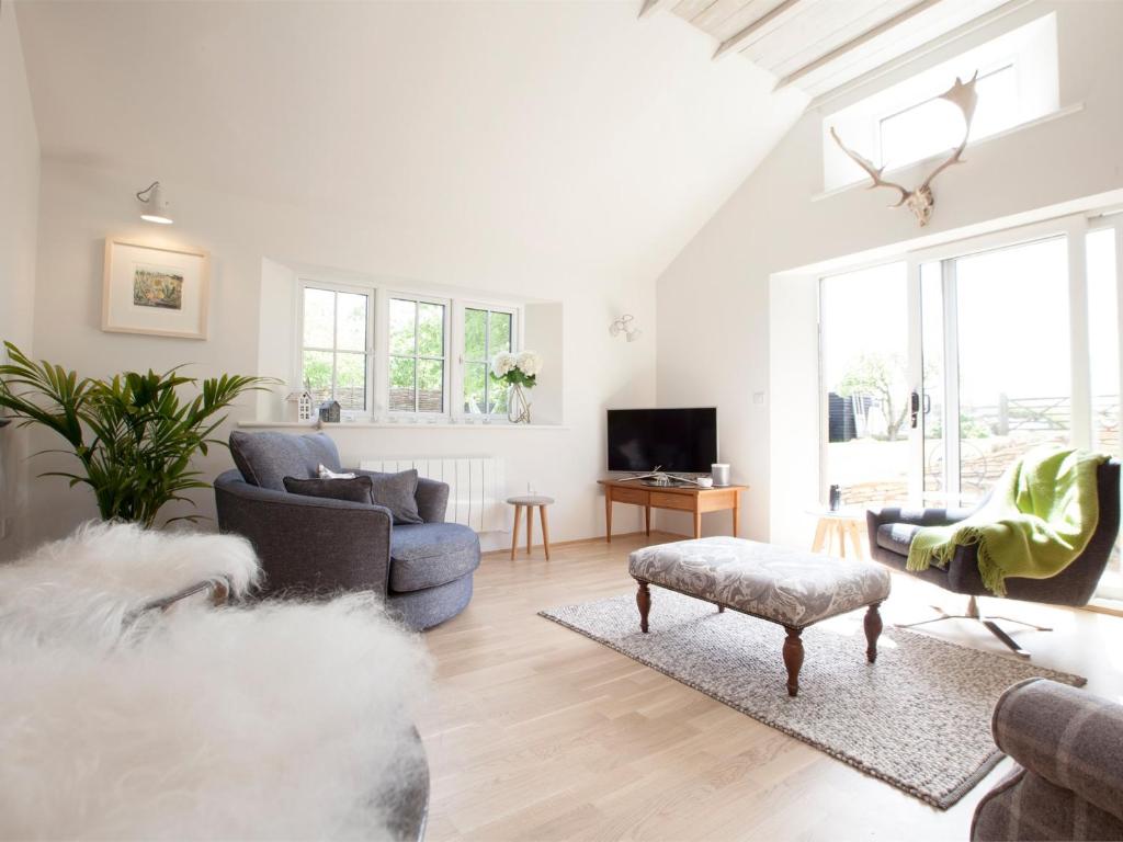 a living room with a couch and chairs and a tv at 1 Bed in Masham G0089 in Thornton Watlass