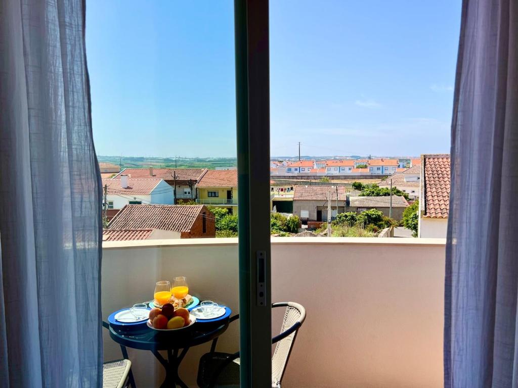 a table with a plate of fruit on a balcony at O caminho da praia in Bicas