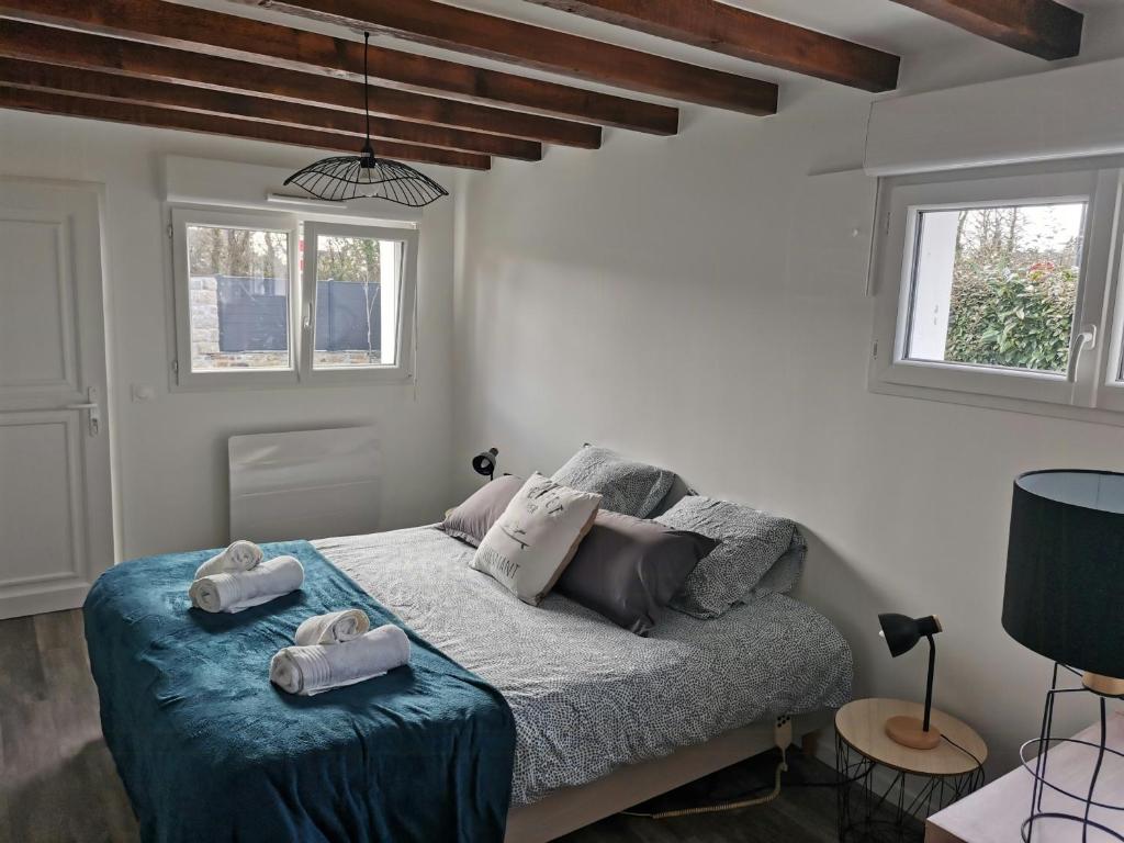 ein Schlafzimmer mit einem Bett mit Handtüchern darauf in der Unterkunft Family House Near Mousterlin Beaches in Fouesnant