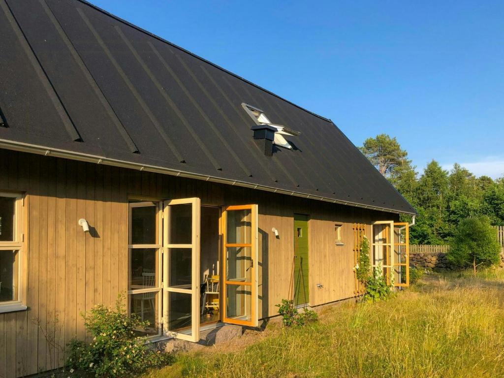 a building with a black roof and a green door at Modern Family Home In Ängelsbäcksstrand in Båstad