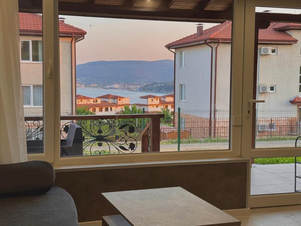a room with a large window looking out onto a balcony at Seagull Apartments in Byala