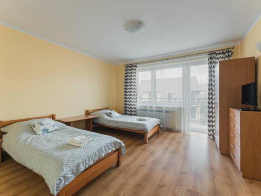 a bedroom with two beds and a large window at Nocleg Wadowice 2 in Wadowice