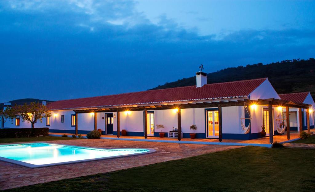 a house with a pool in front of it at night at O Monte do Alhinho - Turismo Rural in Monte Costa