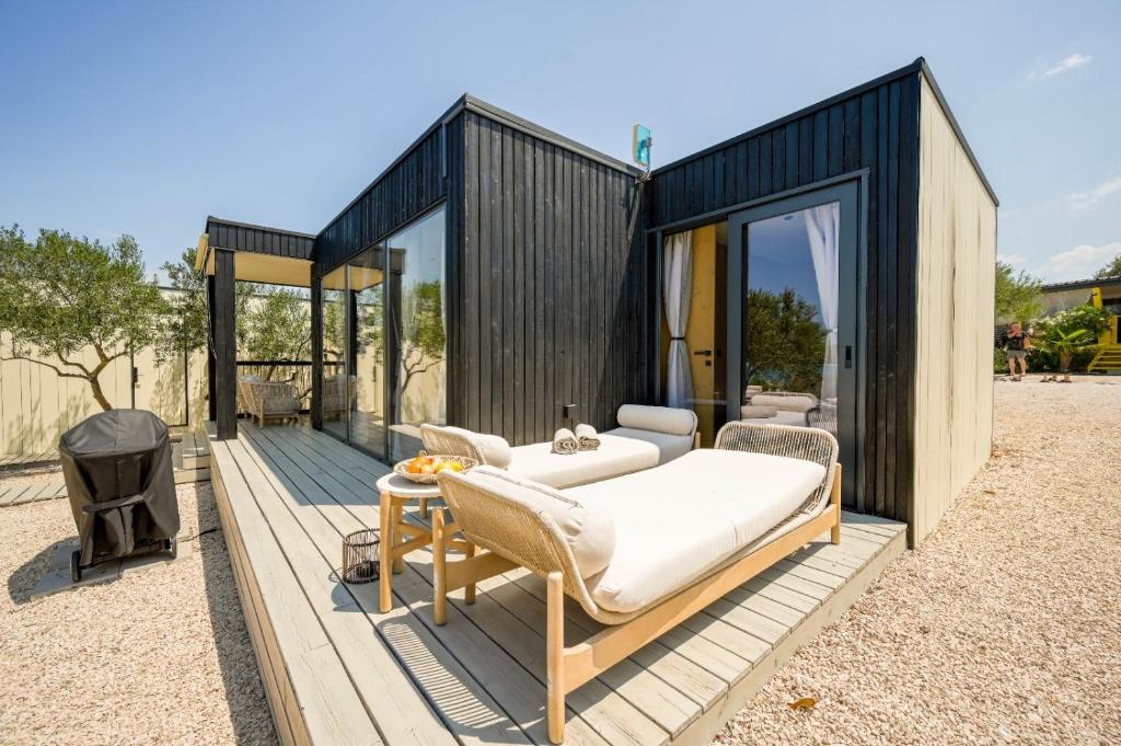 un contenedor de carga negro con una cama en una cubierta en TheBeachVilla 3, en Tisno