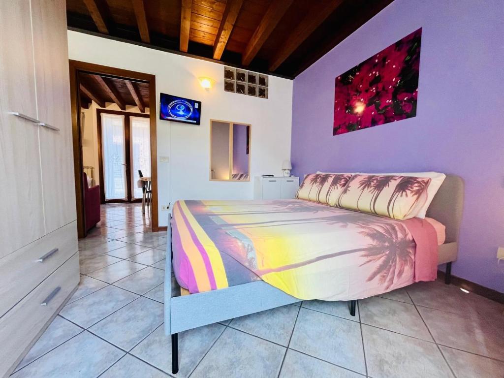 a bedroom with a bed in a room with purple walls at New Apartment on Ground Floor with Terrace in Desenzano del Garda