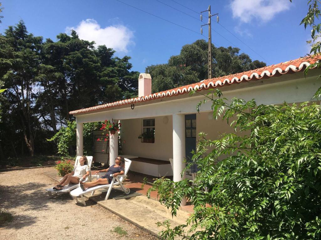 two people sitting in chairs outside of a house at Arneiro de Valverde - Nature & Magical Sunset in Odemira