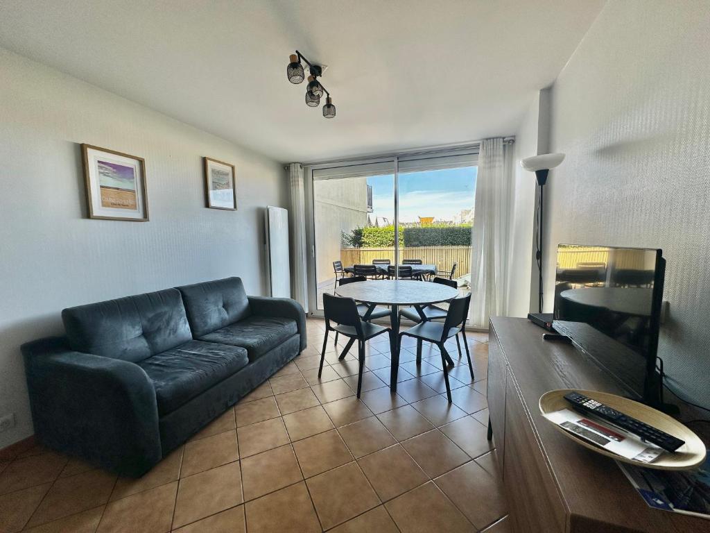 un salon avec un canapé et une table dans l'établissement Loubapa, appartement en rez-de-jardin, à Courseulles-sur-Mer