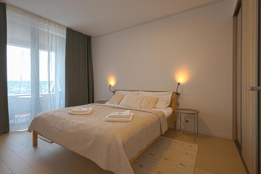 a bedroom with a bed with two towels on it at SKAU Sky Park Green by Zaha Hadid 22 floor 1 Tower Panoramic View Free Parking in Bratislava