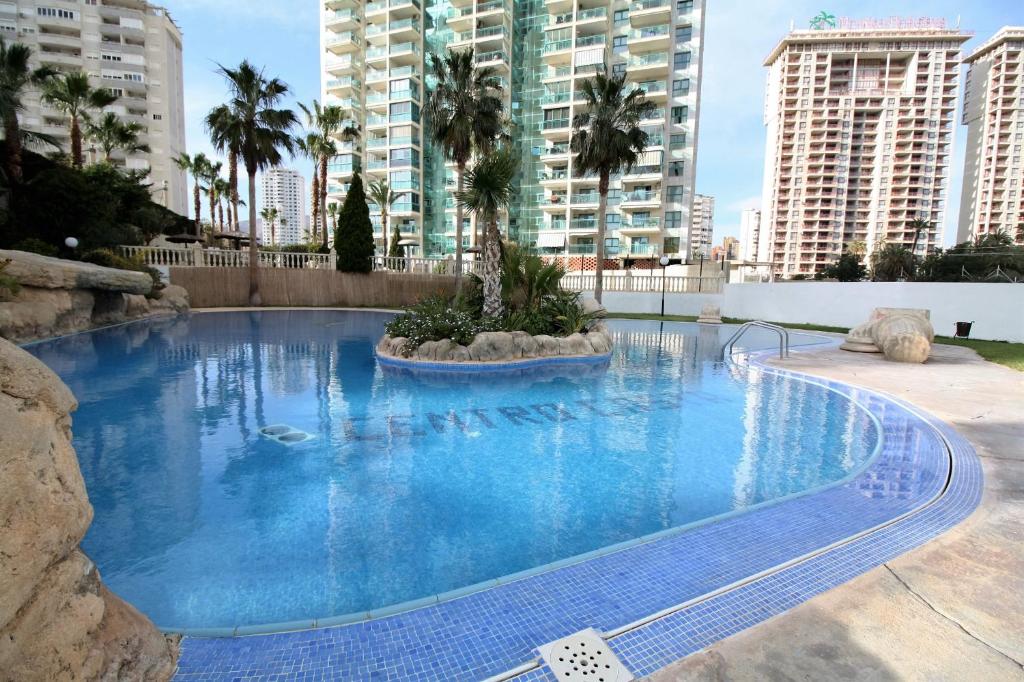 a large blue swimming pool with palm trees and buildings at T252 - Atrium Beach 2 - 2004 Finestrat in Cala de Finestrat