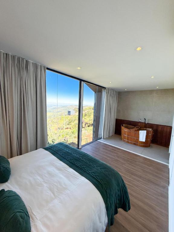 a bedroom with a large bed and a large window at Rancho Churrascada in Espirito Santo Do Pinhal