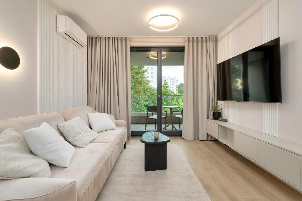 ein Wohnzimmer mit Sofa und Fernseher in der Unterkunft Luxury Apartment with Parking and Air Conditioning in Sopot by Renters Prestige in Sopot