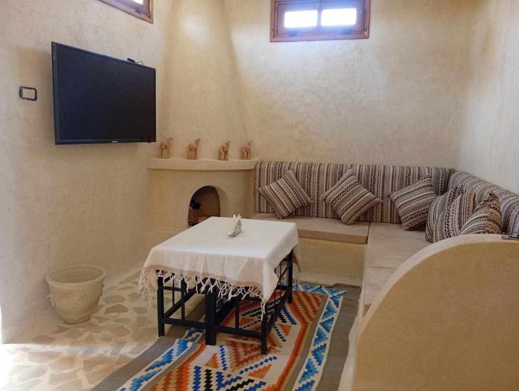 a living room with a couch and a tv at Elhamma Resort Studio in Tozeur
