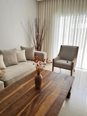 a living room with a couch and a table and a chair at Appartement cosy et chaleureux in Hammam Sousse