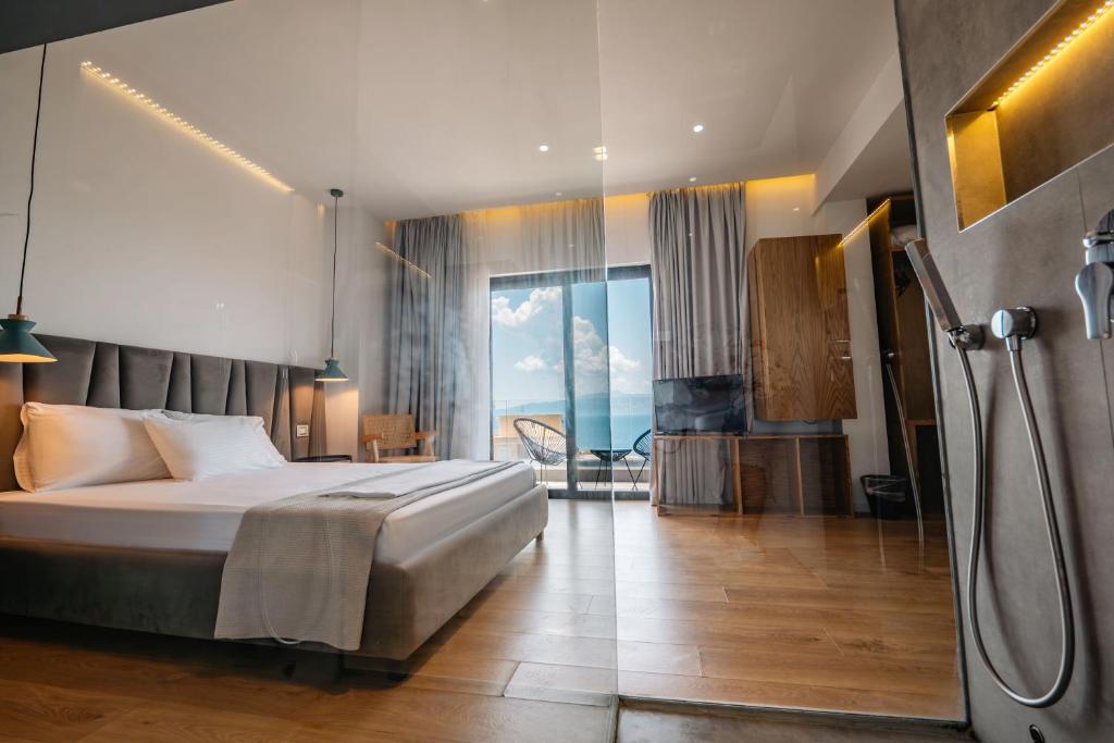 a hotel room with a bed and a view of the ocean at Kanes Boutique Hotel in Sarandë