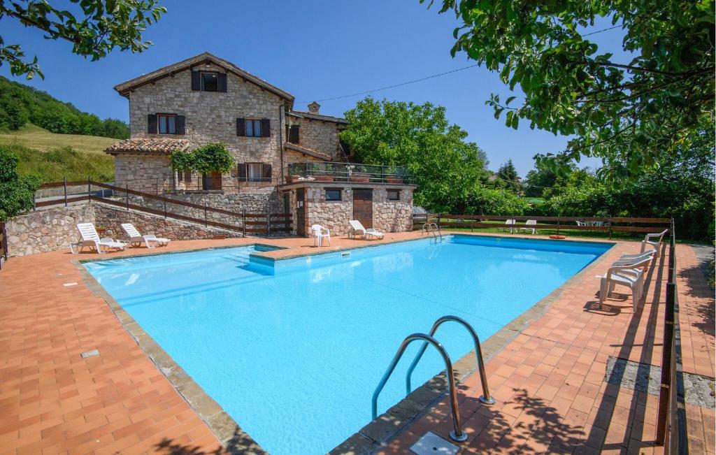 an image of a swimming pool in front of a house at Cozy Apartment In Montemonaco in Montemonaco