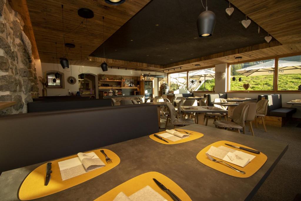 een restaurant met gele eettafels en stoelen bij Bar-Restaurant-Pizzeria Antermont B&B in Carezza al Lago