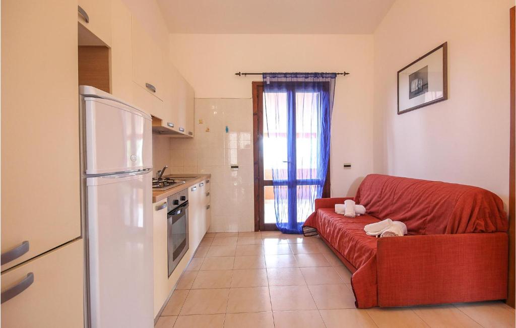 a living room with a red couch in a kitchen at Awesome Apartment In Costa Rei -Ca- With Wifi in Monte Nai