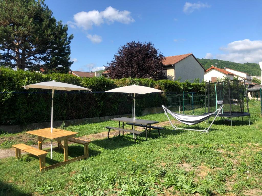 two picnic tables with umbrellas and a hammock at Baker's house in Clermont-Ferrand