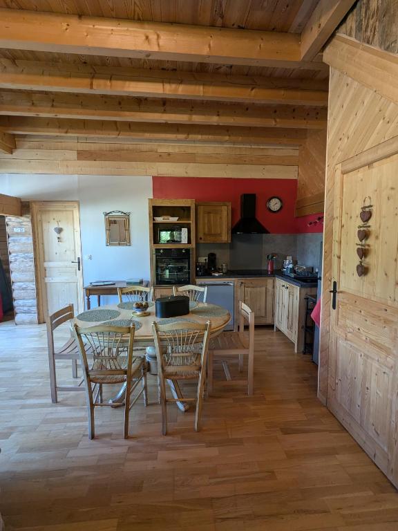 a kitchen with a table and chairs in a room at La Grange in Le Noyer