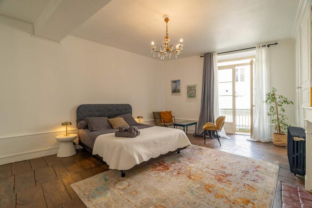 a bedroom with a bed and a chandelier at Les Suites de Bellac in Bellac
