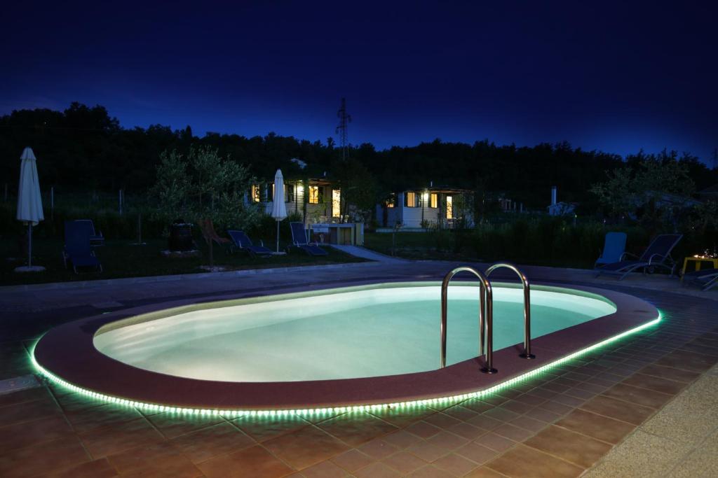 a swimming pool with lights around it at night at Mobile Homes Romantik in Labin