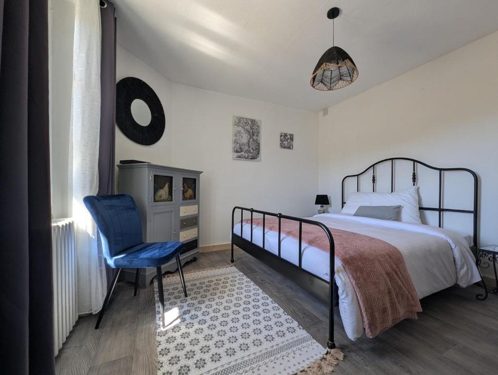 a bedroom with a bed and a blue chair at Le Jardin Secret, Vue sur le château & Parking in Foix