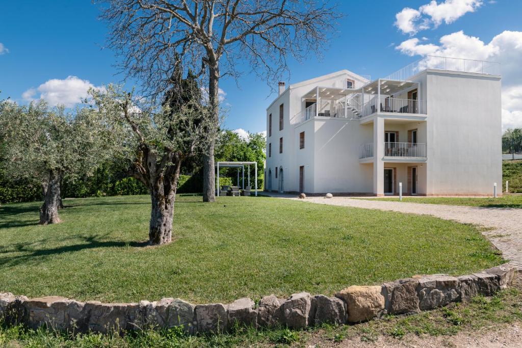 Biały dom z drzewami przed nim w obiekcie Agriturismo Le Masciare w mieście Paternopoli