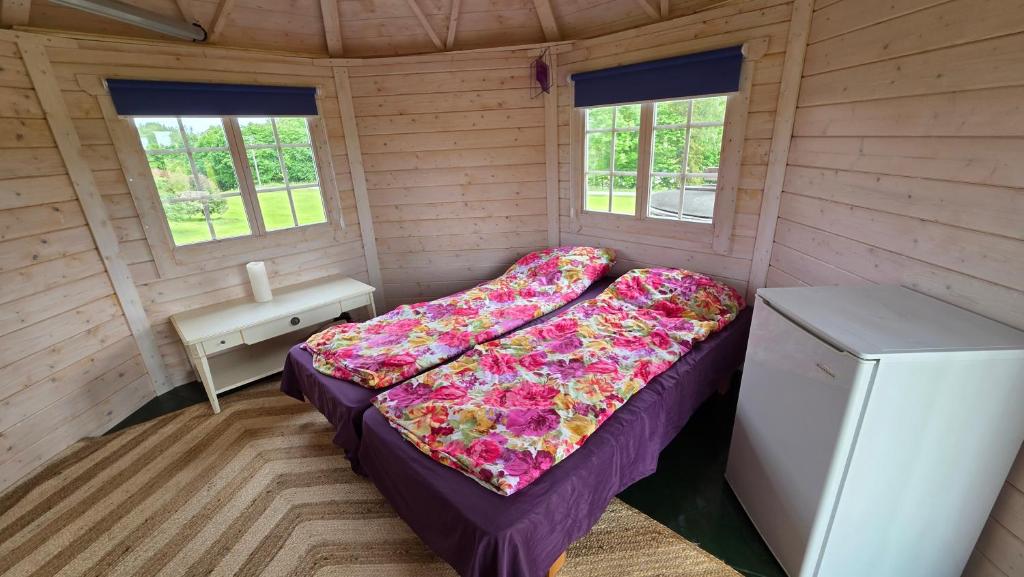 a small room with a bed and a refrigerator at Järvevaatega Puhkemajake in Nüpli